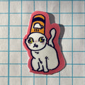 Sticker of a cat with a yellow hat on a grid background