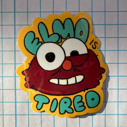 Sticker of a tired cartoon character with 'Elmo is Tired' text on a grid background