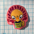 Cartoon character sticker with a cup labeled 'That's Tea' on a grid background