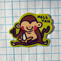 Sticker of a monkey with 'HELL YAH' text on a grid background