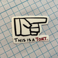Hand-drawn sticker with a pointing hand icon and 'This is a tort' text on a grid background