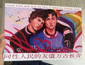 Print with two people and colorful design held by a hand, with text on the top and bottom.
